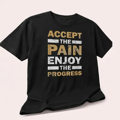 Gold, white, and black motivational fitness t-shirt with bold distressed text — printed on a unisex t-shirt (angled view)