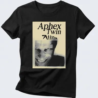 Black and white illustration featuring Aphex Twin text, evolving figures, and a smiling face — printed on a women's shirt