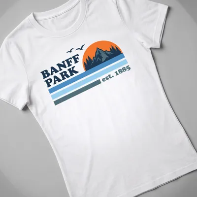 Vintage style t-shirt featuring a mountain sunset with trees in orange and blue — printed on a women's shirt