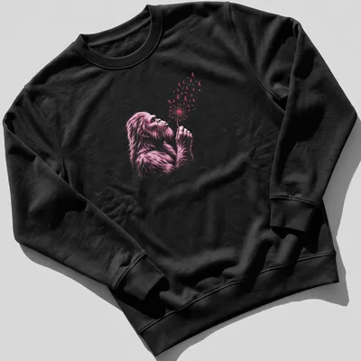 Illustration of Bigfoot blowing a dandelion with pink ribbons intertwined — printed on a unisex sweatshirt