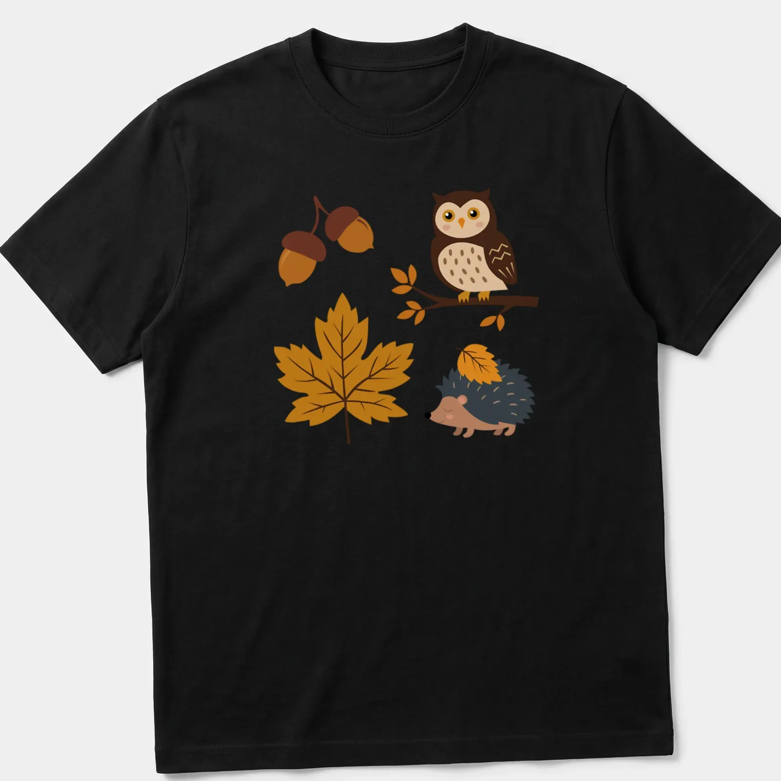 Kawaii design with an owl and hedgehog surrounded by acorns and leaves in autumn colors — printed on a unisex t-shirt