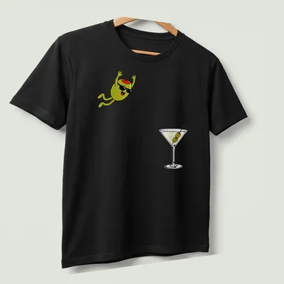 Cartoon olive diving into a dirty martini cocktail, illustrated in green, black, white, and red — printed on a unisex t-shirt (angled view)