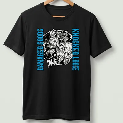 Bold graphic tee with the phrase 'Damaged Goods Knocked Loose' and chaotic illustrated characters in black, blue, and white. — printed on a unisex t-shirt