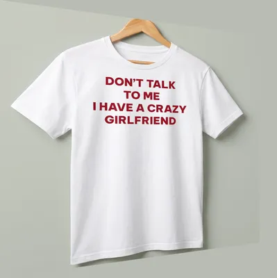 Bold typography tee stating Don't Talk To Me I Have A Crazy Girlfriend in red and white — printed on a unisex t-shirt (angled view)