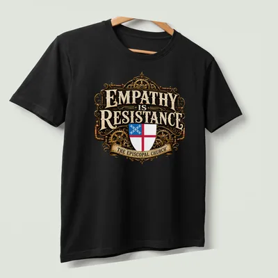 Steampunk shield emblem with ornate text: 'EMPATHY is RESISTANCE THE EPISCOPAL CHURCH' — printed on a unisex t-shirt (angled view)