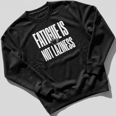 Bold typography tee featuring a coffee cup and the text 'Fatigue Is Not Laziness' in white on a purple background. — printed on a unisex sweatshirt