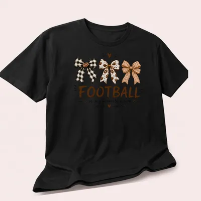 Whimsical illustration of football-themed bows with the text Football is my favorite season — printed on a unisex t-shirt (angled view)
