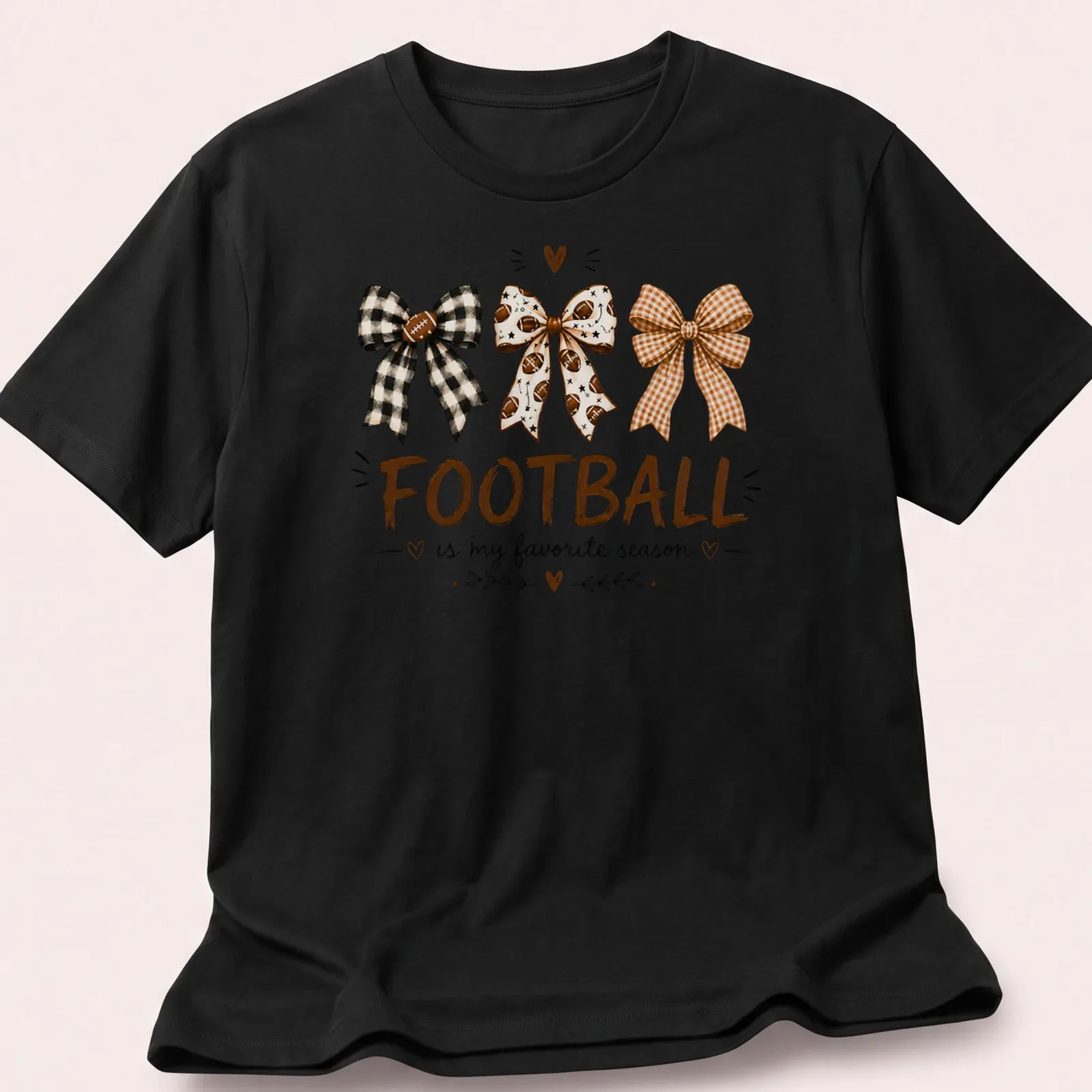 Whimsical illustration of football-themed bows with the text Football is my favorite season — printed on a unisex t-shirt