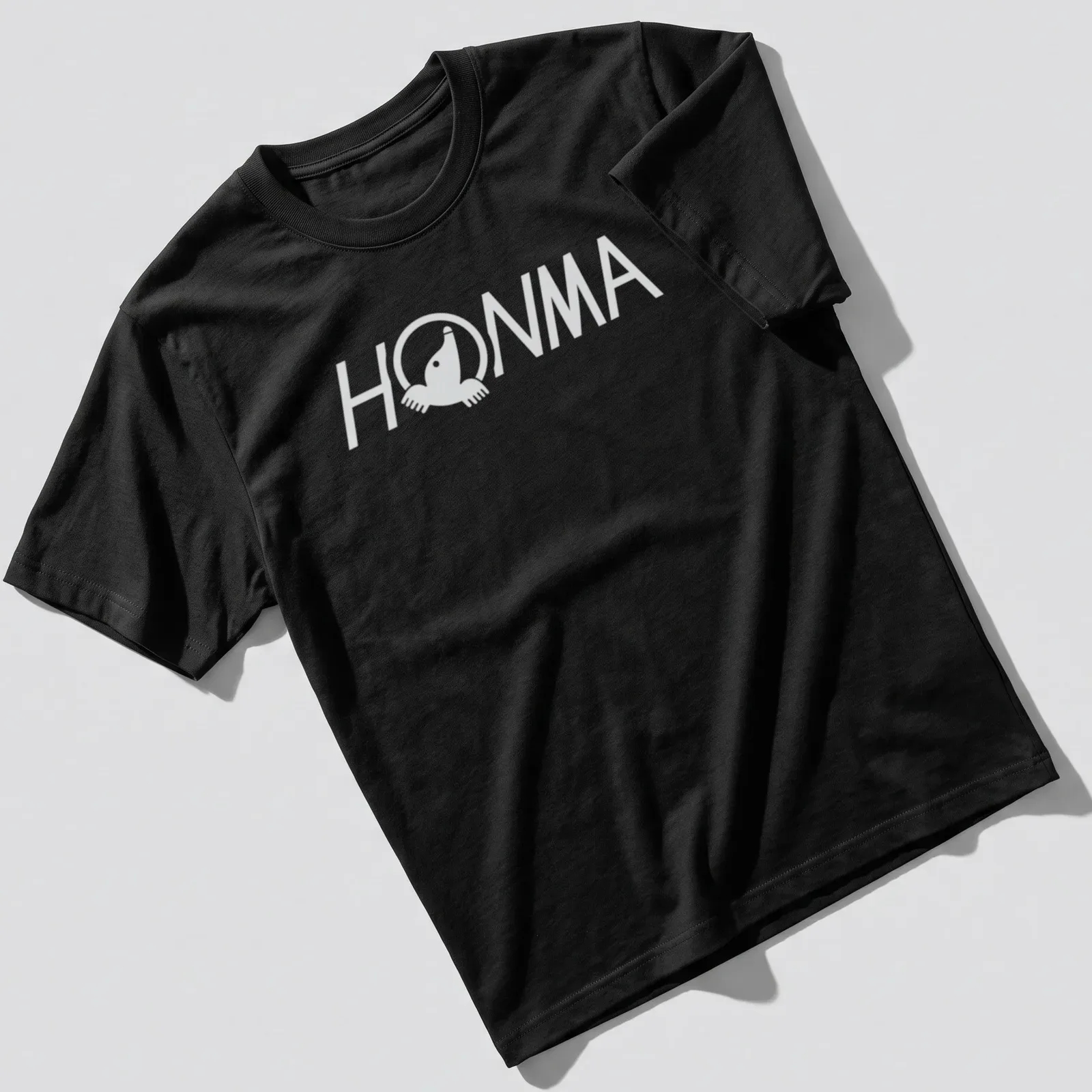 Black and white HOMMA logo in a clean vector style on a t-shirt. — printed on a unisex t-shirt