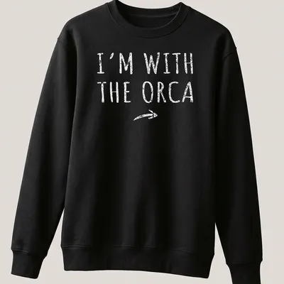 Playful orca-themed shirt with bold text 'I'm With The Orca' for Halloween — printed on a unisex sweatshirt