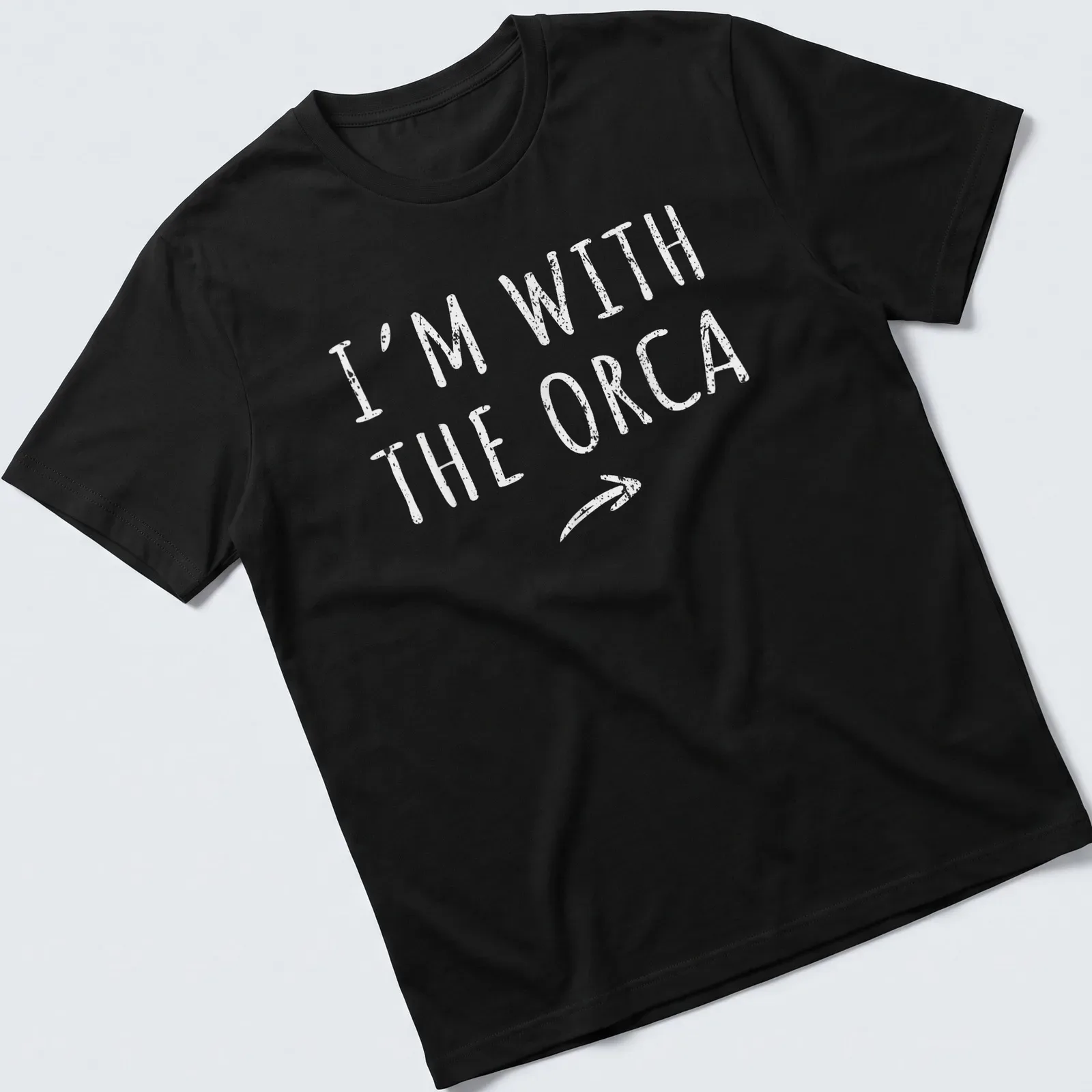 Playful orca-themed shirt with bold text 'I'm With The Orca' for Halloween — printed on a unisex t-shirt