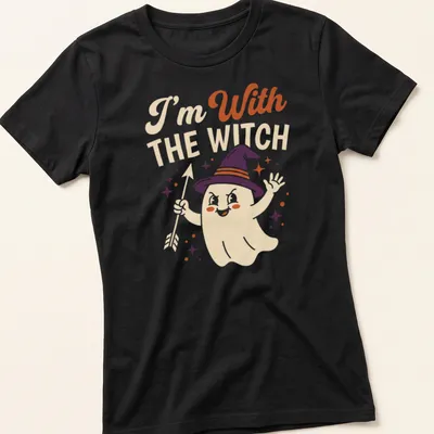 Playful cartoon ghost with witch hat and text 'I'm With THE WITCH' in Halloween colors — printed on a women's shirt