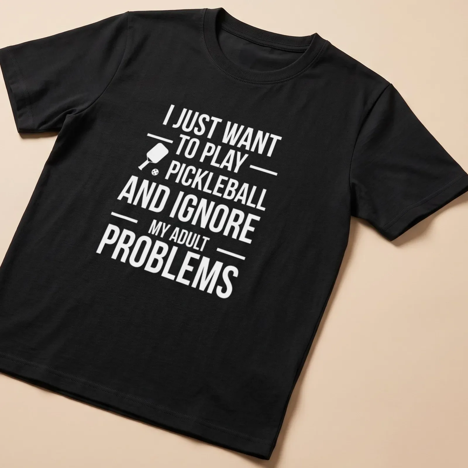 Typography t-shirt with the phrase about ignoring adult problems to play pickleball and a cartoon player — printed on a unisex t-shirt