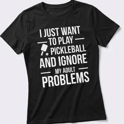 Typography t-shirt with the phrase about ignoring adult problems to play pickleball and a cartoon player — printed on a women's shirt