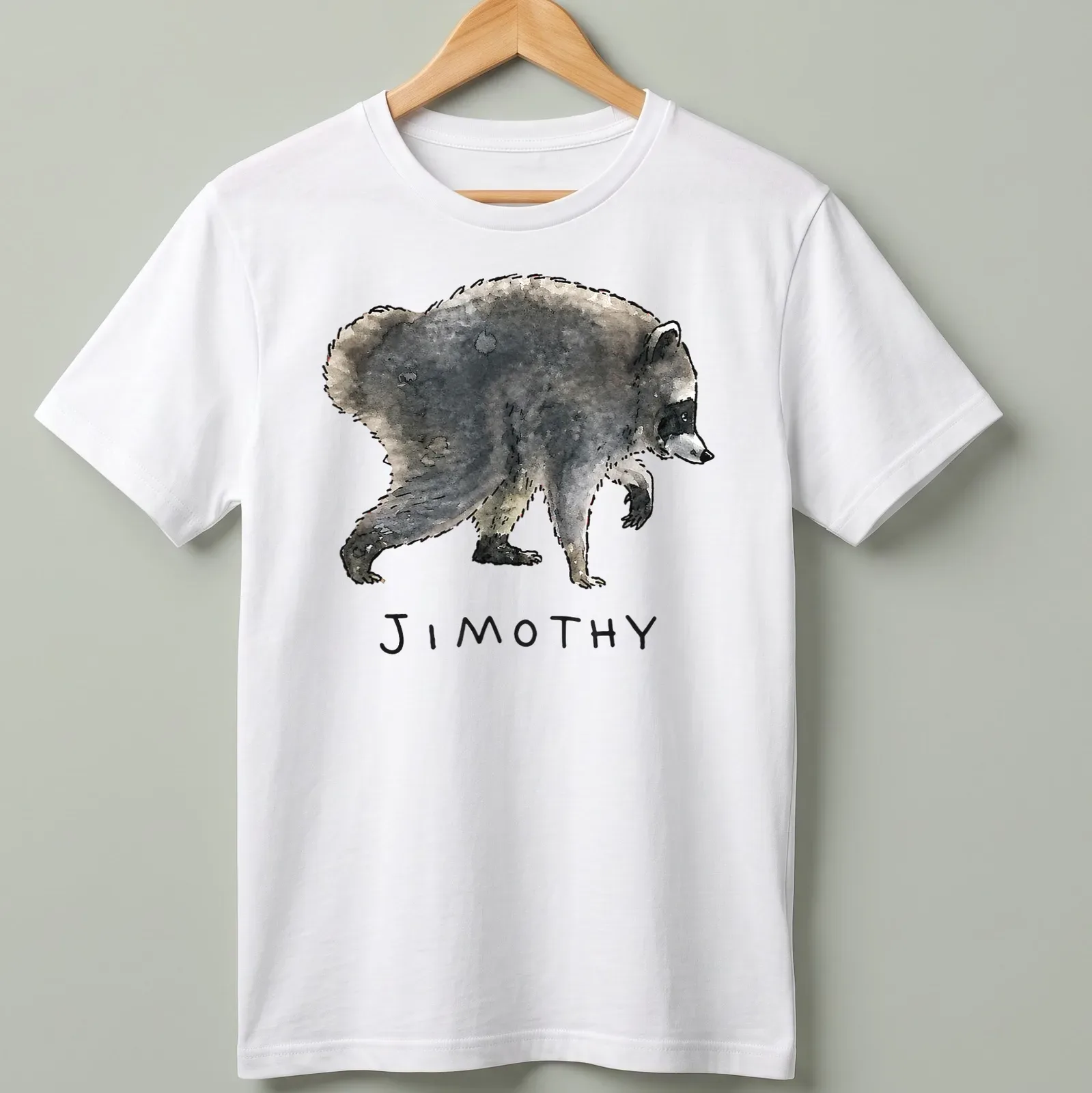 Watercolor raccoon design with playful text 'JIMOTHY' in gray and black tones. — printed on a unisex t-shirt