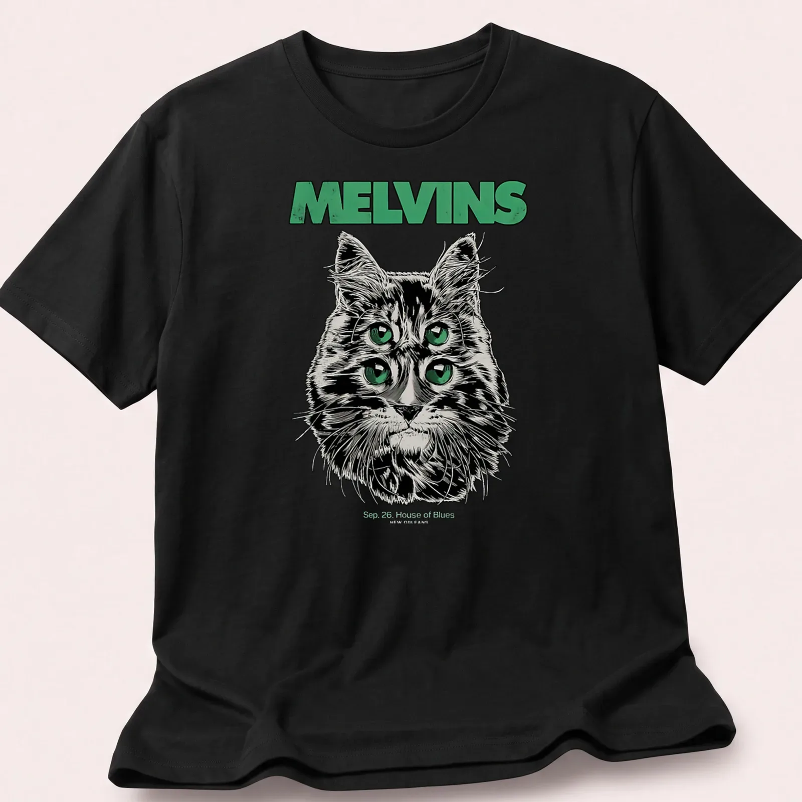 Illustrative print of a four-eyed cat with Melvins concert details in black, green, and white — printed on a unisex t-shirt