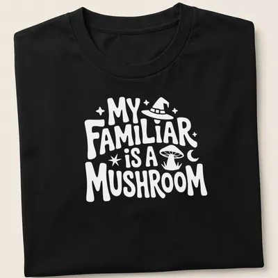Whimsical illustration of a green and brown mushroom with the text 'My Familiar Is A Mushroom' — printed on a unisex t-shirt