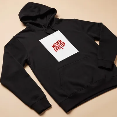 Bold typography reads 'NEVER GIVE UP' in red and white — printed on a unisex hoodie