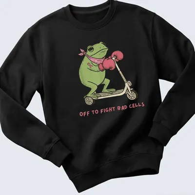 Cartoon frog on a scooter with text saying 'Off to Fight Bad Cells' in playful colors. — printed on a unisex sweatshirt
