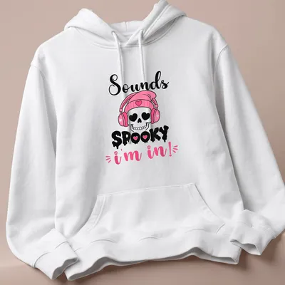 Cartoon skull with headphones and text 'Sounds Spooky I'm in!' in pink, black, and white — printed on a unisex hoodie