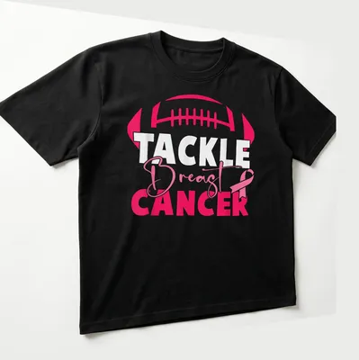 Bold football and pink ribbon design promoting breast cancer awareness — printed on a unisex t-shirt (angled view)