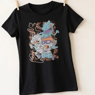 Cartoon of terrified babies running from a blue monster in bright colors — printed on a women's shirt