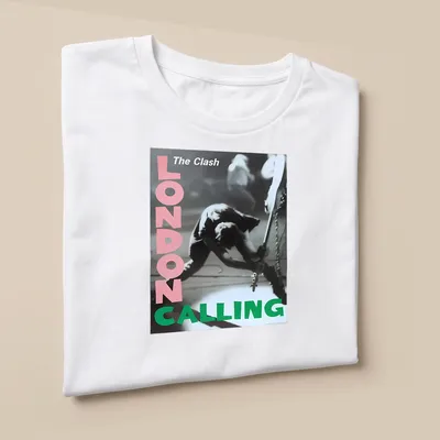 Vintage concert poster style t-shirt featuring The Clash guitarist in pink, green, black and white — printed on a unisex t-shirt (angled view)