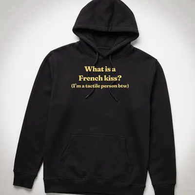 Text print reading What is a French kiss? I’m a tactile person btw in yellow and white — printed on a unisex hoodie