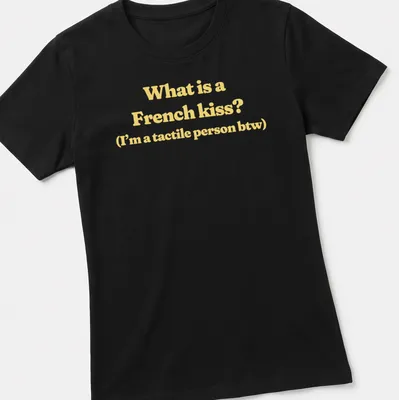 Text print reading What is a French kiss? I’m a tactile person btw in yellow and white — printed on a women's shirt